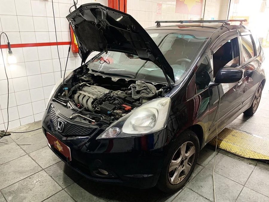 Carro com o capô aberto na oficina PMAXXI para limpeza do sistema de arrefecimento do motor